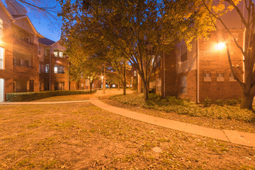 Typical apartment complex with beautiful fall foliage color at blue hour. Rental housing building...