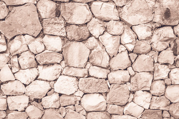 Seamless Brown pattern of decorative cream slate stone wall surface of modern style design decorative uneven cracked realmasonry wall of multicolored stones or blocks with cement or sandstone.