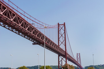 Closeup of the bridge '25 of April' against blue sky on a clear day