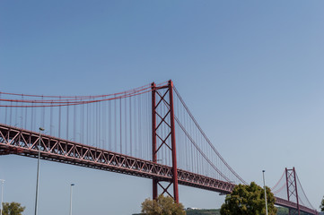 Fototapeta na wymiar Closeup of the bridge '25 of April' against blue sky on a clear day