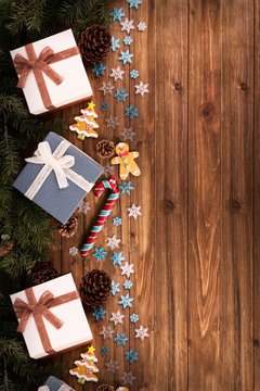 Gift boxes and decoration under Christmas tree, wooden plank in background, directly above.