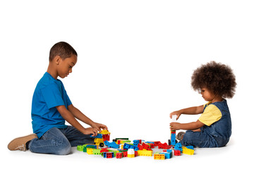 Little african kids playing with lots of colorful plastic blocks indoor. Isolated