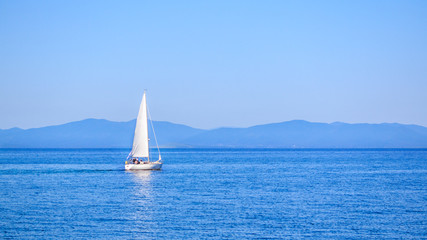 Sailboat during the international sailing regatta on the background of the Russian Island