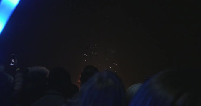 Fireworks exploding over heads of crowd (4K)
