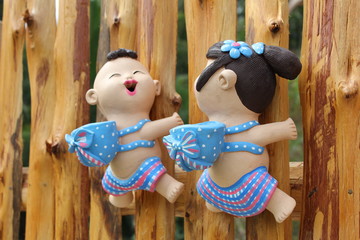couple cute doll climbing on wooden wall background