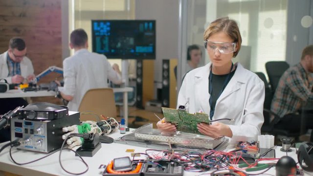 Portrait of young woman examining motherboard
