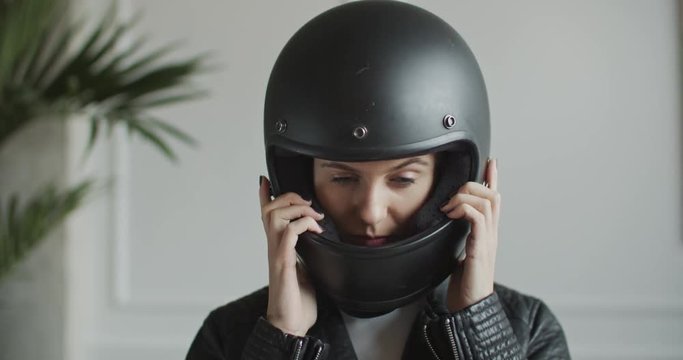 woman putting on retro helmet in bright room