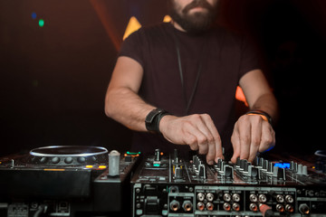 Dj mixes the track in the nightclub at party