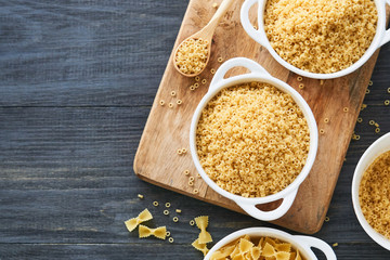 Uncooked anellini pasta in a bowl on wooden background