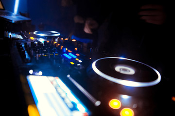 Fototapeta na wymiar DJ turntable console mixer controlling with two hand in concert nightclub stage.