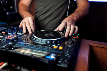 Dj playing disco house progressive electro music at the concert. DJ hands on equipment