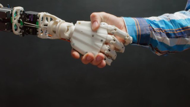 Close up of robot and human shaking hands