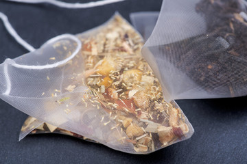 Organic whole leaf earl grey and chamomile citrus tea in pyramid pouches on natural stone background