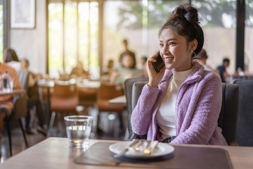 woman talking on mobile phone in restaurant
