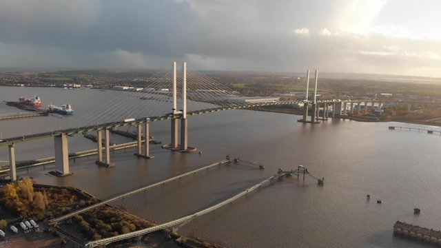 An aerial view of the traffic crossing the Queen Elisabeth II bridge at sunset
