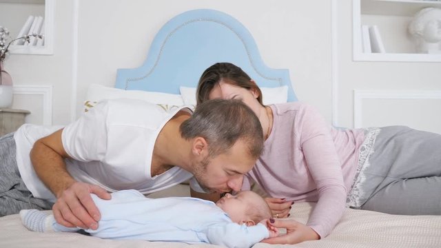 Attractive man and woman looking at sweet sleeping baby in bedroom.