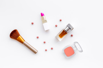 Set of pink cosmetics. Lipstick, bulk, eyeshadow, perfume near brushes on white background top view