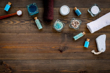 Spa set with sea salt, towel, pumice stone for foot on dark wooden background top space for text