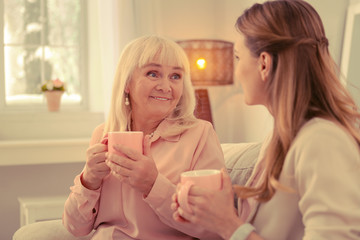 Obraz na płótnie Canvas Nice aged woman holding a cup of tea