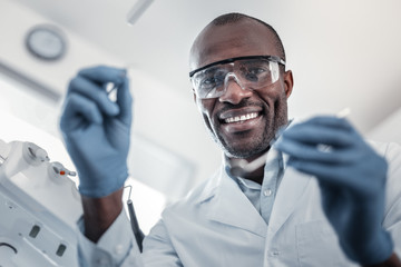 Cheerful international stomatologist working in modern clinic