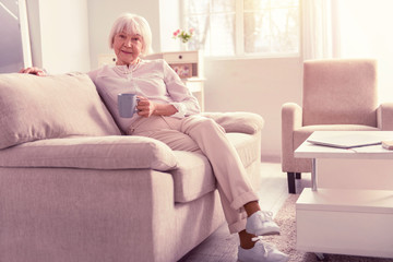 Nice positive pensioner wearing light fashionable clothes