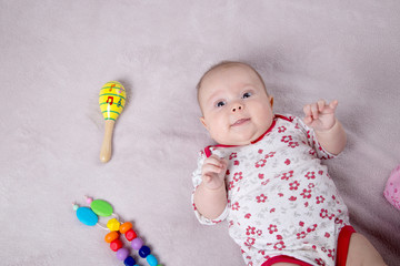 Baby girl smiling around baby toys