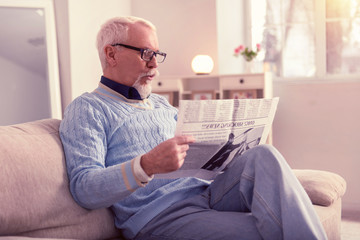 Fototapeta premium Curious senior surprised with materials in newspaper