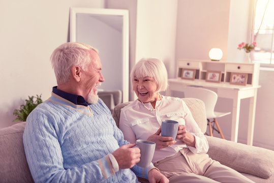 Nice elderly couple having great time on couch