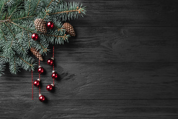 Holiday Christmas background with spruce branch on a dark wood table. Xmas and happy new year greeting card. Copy space. View from above. Flat location, place for text.