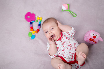 Baby girl smiling around baby toys