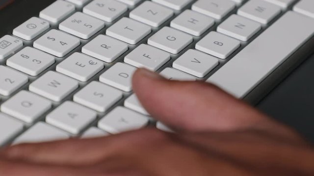 Extreme close up of male fingers and thumbs operating a stylish keyboard shortcut