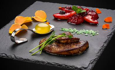 Foie Gras with berries flambe on a dark background © GrumJum