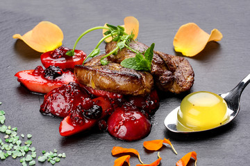 Foie Gras with berries flambe on a dark background