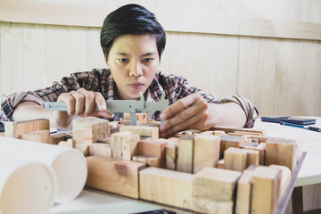 Concept architects, Hand of asian young using Vernier caliper equipment architects On the desk with...