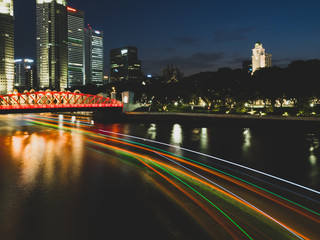 Fototapeta premium Boat Light Trails with Singapore's Central Business District and the bridge