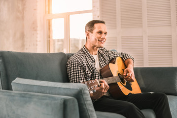 Eager creative man mastering his guitar playing skills.