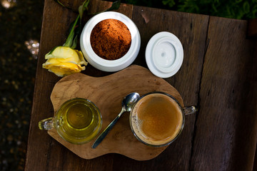 Coffee and tea are on the wooden table in green garden
