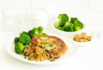 Fried pork steak with broccoli and onion sauce.