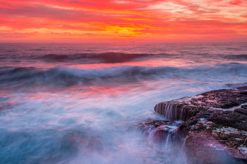 Fototapeta premium Niebo nad oceanem, gdy fale falują nad skałami