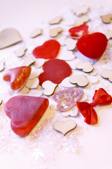 Artificial snowflakes and red decorative hearts on white soft background