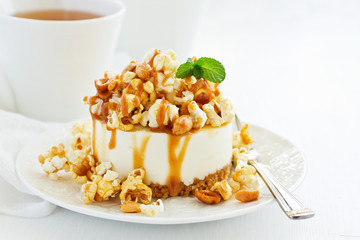 A delicious New York chocolate cheesecake with popcorn and caramel. close-up.