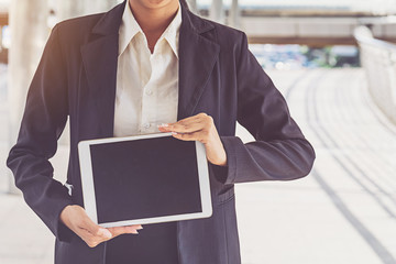 businesswoman in suit using tablet at city