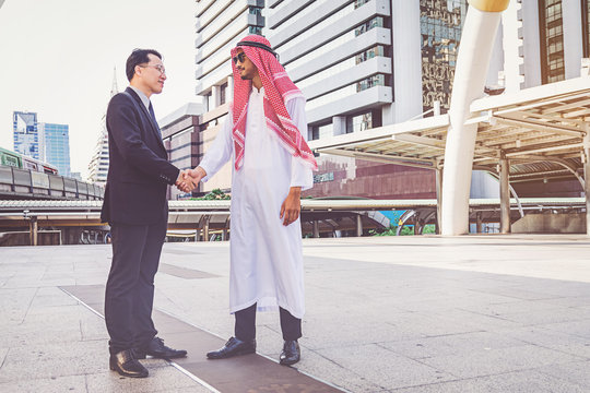 Arabic businessman giving an handshake to his business partner, on construction site