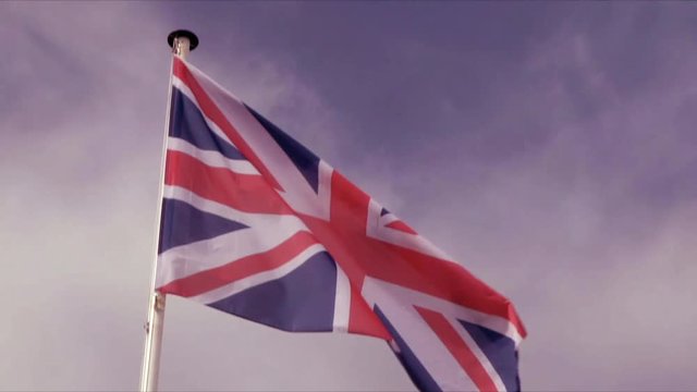 Slow Motion Union Jack flag of the United Kingdom of Great Britain or UK flag waving in the wind | 4K - VINTAGE STYLE - 8MM FILM MAGENTA FILMLOOK - PROJECTOR- SLOW MOTION - SLOMO