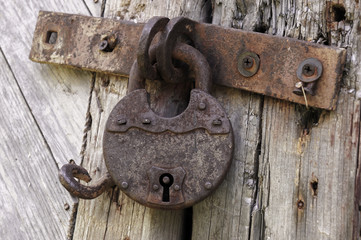 Old rusted lock on a rustic door with decorative natural weathered wood planks