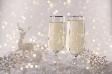New Year and Christmas Celebration .Two Champagne Glasses and Holiday decoration. Beautiful shiny place setting for Christmas. Sparkler background, winter season.