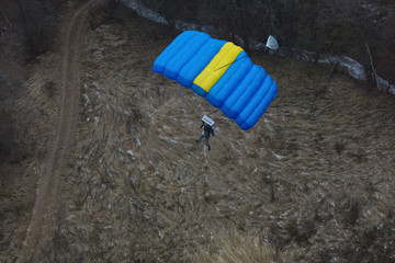 Base jumper with parachute at low altitude before landing. Basejumping.