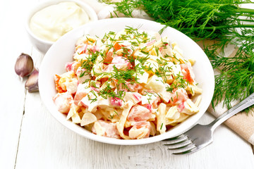 Salad of surimi and eggs with mayonnaise on light board