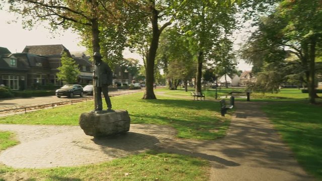 a Walk in a quiet, peaceful and green colored park with the statue of Vincent van Gogh and a pond in the Dutch village of Nuenen during the summer.