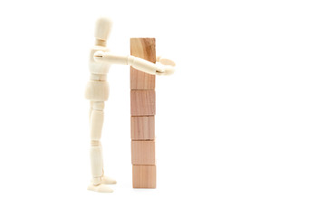 Wooden figure as businessman building tower of wood cubes
